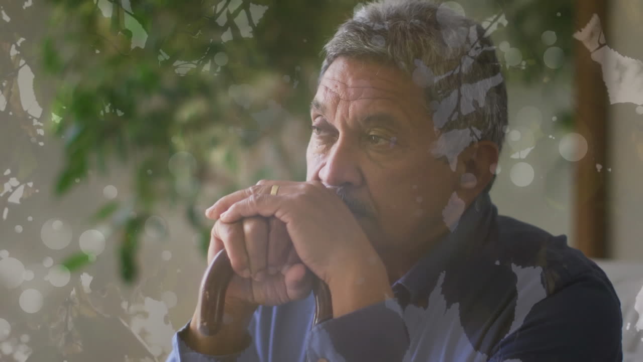 歩く杖に寄りかかっている高齢の双人男性の上に葉のアニメーション