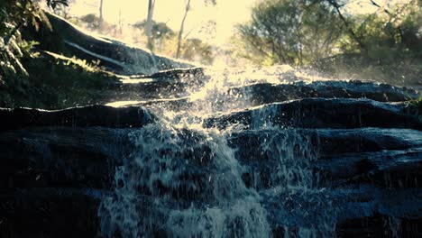 crashing waterfalls on the tiered rocks during sunrise in blue mountains national park in nsw, australia. close-up shot