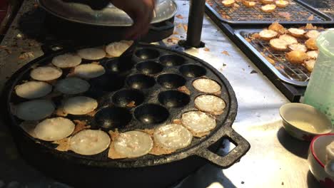 concepto de cocina. tipo de carne dulce tailandesa. leche de coco mezclada con postre frito en polvo en el mercado de comida callejera tailandés de la noche. postre de carne tradicional tailandesa, panqueque, pudín. imágenes de 4k.