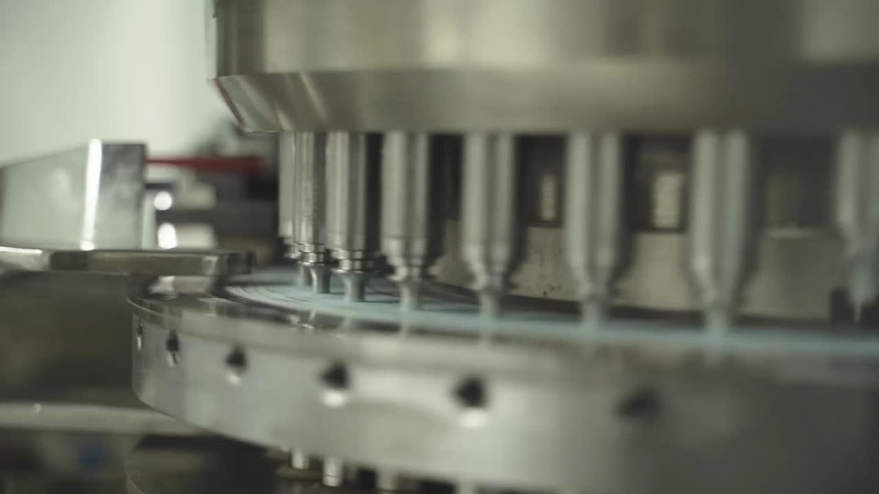 Modern filling machine operating in pharmaceutical plant with multiple heads.