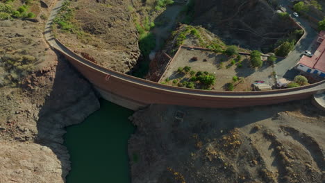 Filmische-Luftaufnahme-Der-Stützmauer-Des-Ayagaures-Staudamms-Auf-Der-Insel-Gran-Canaria-An-Einem-Sonnigen-Tag