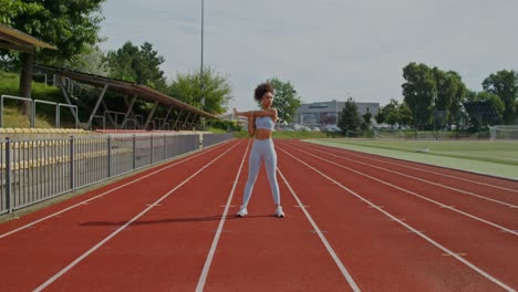 woman stretching on a running track