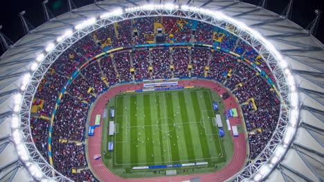 aerial view of a vibrant stadium during a football match, capturing the dynamic atmosphere