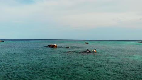 aerial view of man and woman in a kayak paddling near rocks in tropical sea in thailand