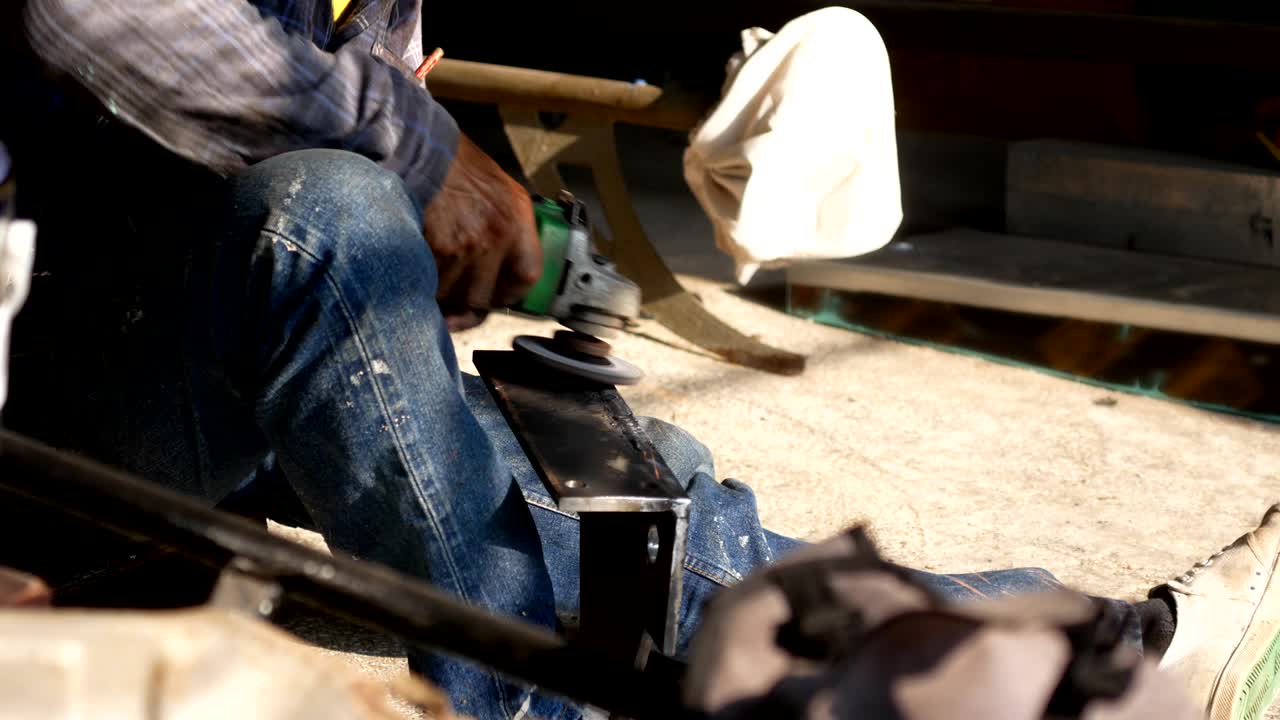 작업실에서 회전 기계로 금속 부품을 는 작업자.