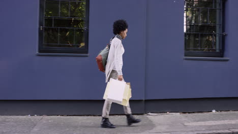 Beautiful-Mixed-race-woman-carrying-shopping-bags-walking-through-city