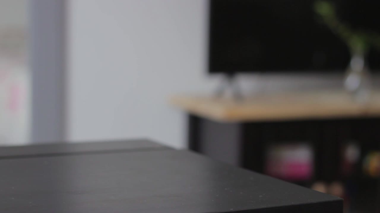 Person taking glass of cola drink and puts down half full in domestic area, static view
