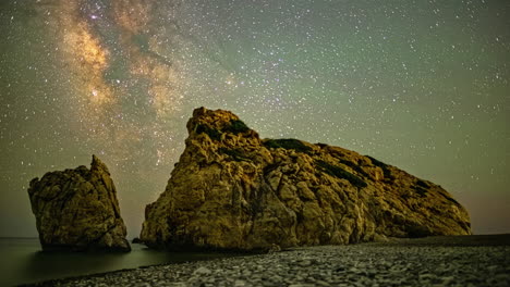 aphrodite's rock against cinematic starry sky in paphos, cyprus