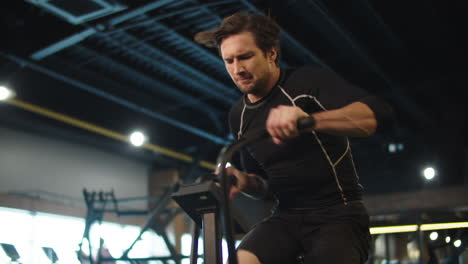 Hombre-En-Forma-Fuerte-Calentando-En-El-Club.-Hombre-Deportivo-Haciendo-Ejercicio-En-Bicicleta-En-El-Gimnasio