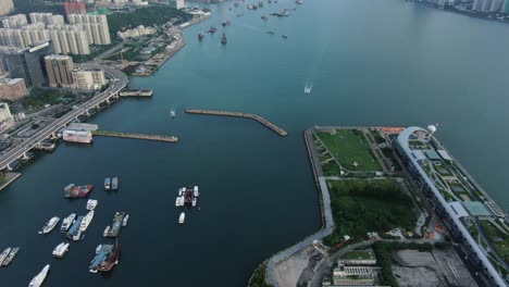 hong kong marina with anchored boats and kwun tong area buildings, aerial view