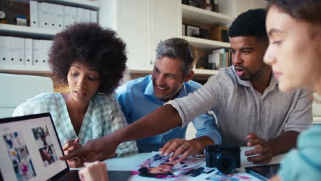 Male-And-Female-Team-Of-Fashion-Designers-With-Laptop-Meeting-In-Modern-Office