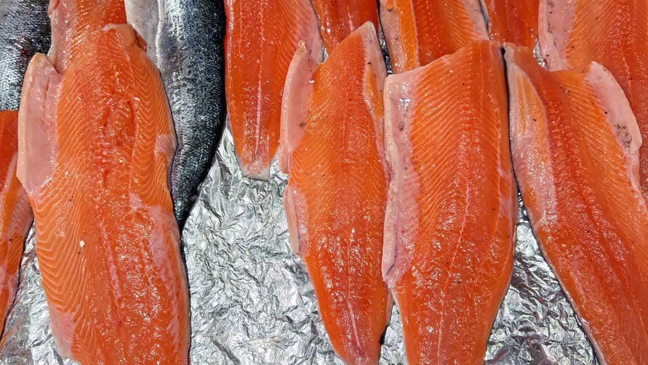 Filés de salmão fresco e cru e peixe inteiro em exposição para venda em um mercado de frutos do mar. Close-up.