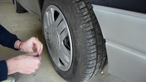 auto mechanic was checking pressure and inflating car tire for safety before departure