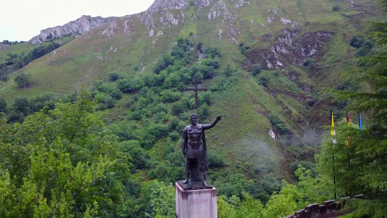 Riprese aeree con drone della basilica di Covadonga e del santuario della grotta sacra di Santa Cueva nelle Asturie, Spagna. Torri gotiche e un paesaggio montano verde circondano questo sito di pellegrinaggio mariano con Don Pelayo.