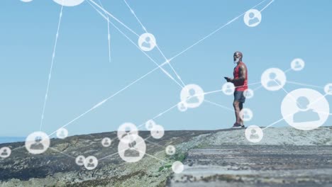 Animation-of-network-of-connections-over-senior-african-american-man-using-smartphone-at-beach