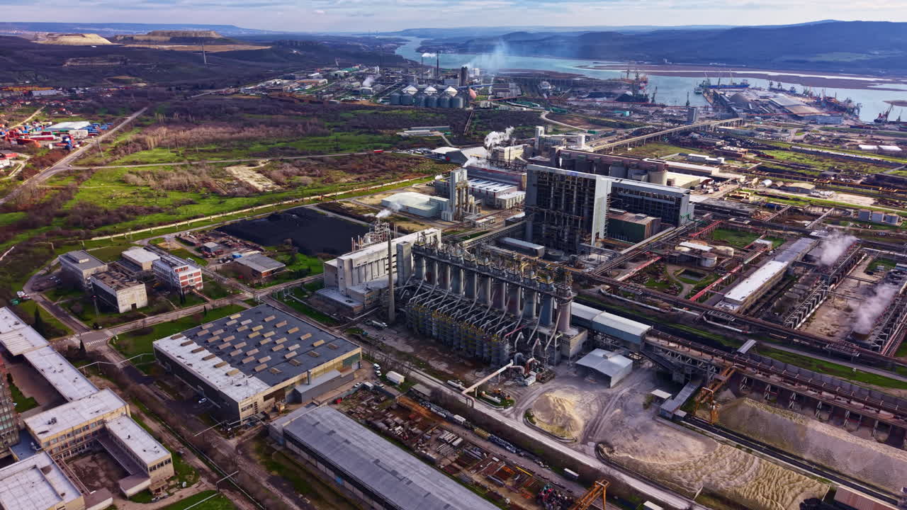 Gündüz vakti bir nehrin yakınında fabrikalar, makineler ve doğal manzarası olan endüstriyel alan