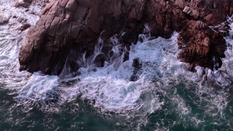 Vista-Aérea-De-Las-Olas-Del-Océano-Se-Rompe-En-Las-Rocas