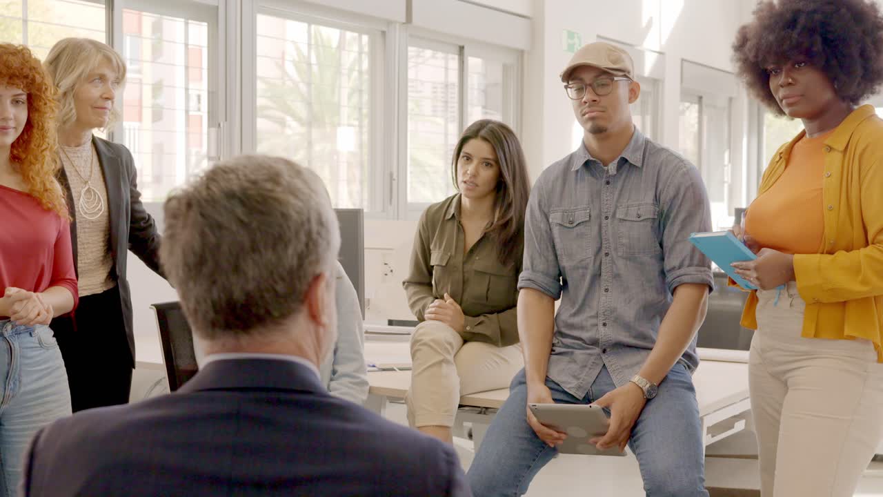 Manager talking to workers in a coworking meeting