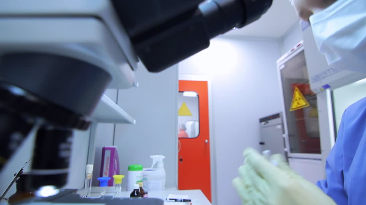 mujer química usando el microscopio en el laboratorio de química en la fábrica