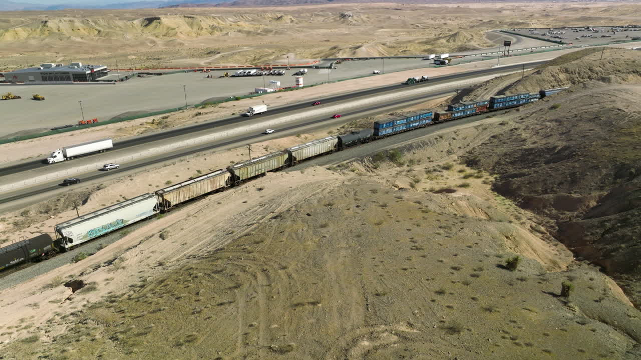 미국 네바다주에서 유조선과 마차를 싣고 긴 화물 열차를 따라 운전하는 자동차와 세미 트레일러 트럭
