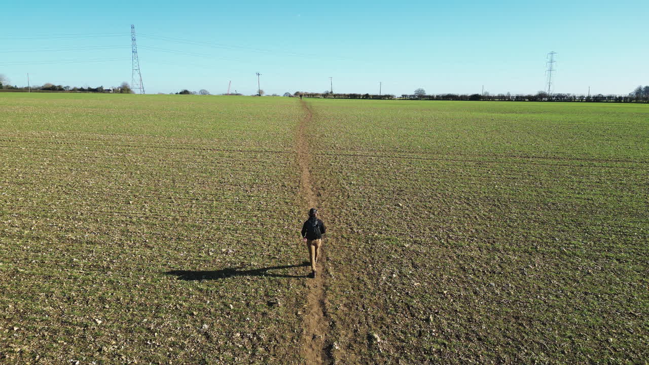 Drone che segue un uomo che cammina attraverso un campo su un sentiero a Great Missenden.