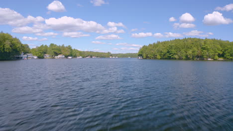 Drone-accelerating-across-lake-in-cottage-country