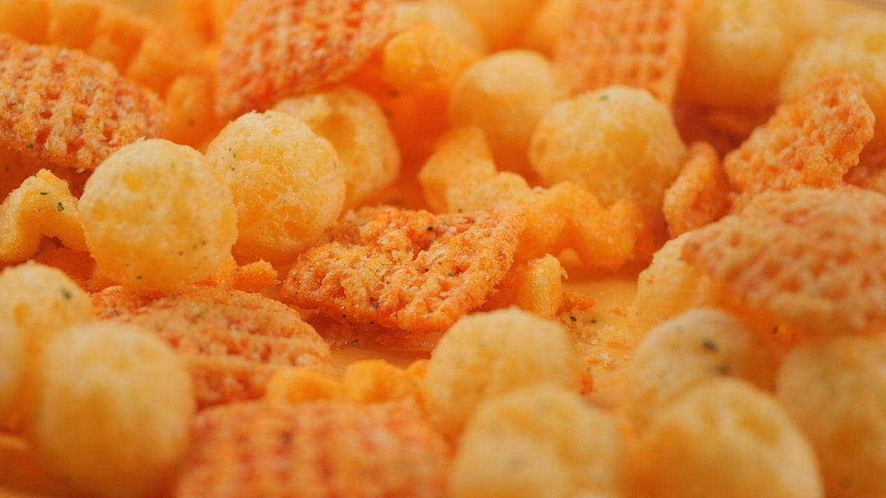 Macro Shot of Different Cheese Puffs and Chips Falling