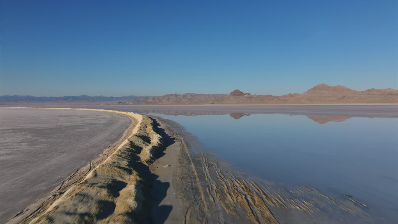 Planícies de Sal de Bonneville com montanhas refletindo na superfície da água do lago no inverno.