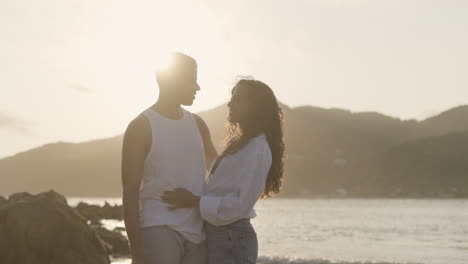 una pareja joven posando en la playa.