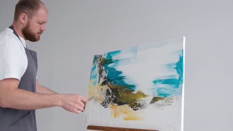 young artist paints an abstract picture in studio master paints a picture with a brush young artist paints an abstract picture in the studio on a white background the master paints on a large canvas with a brush abstract colorful illustration artist concept
