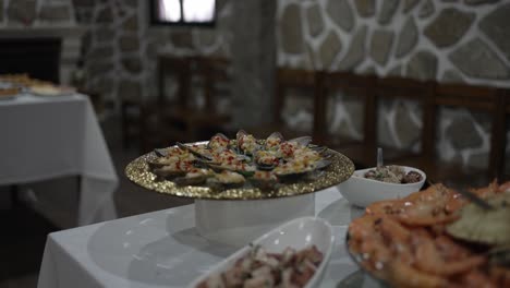 elegant buffet setup with a variety of seafood dishes displayed on a table in a rustic stone walled room, ready for a celebration