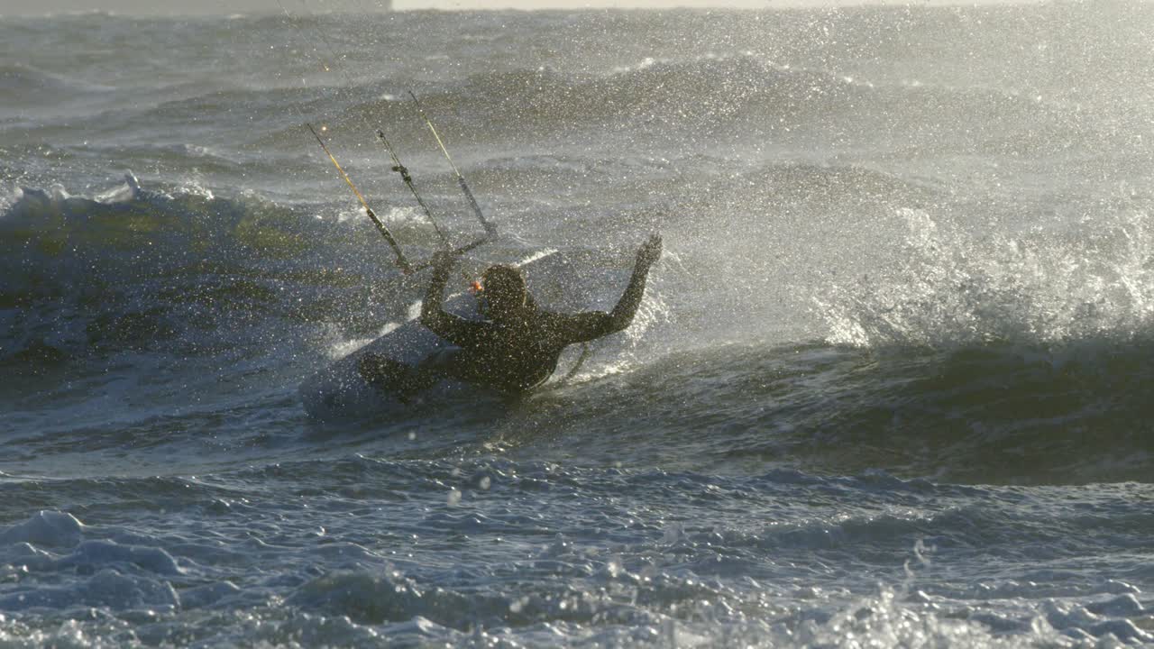 Kiteboarder utfører et triks i en stor bølge