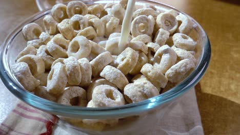 copos de avena crujientes en un tazón para un delicioso desayuno matutino con leche. cámara lenta con toma de seguimiento de rotación.