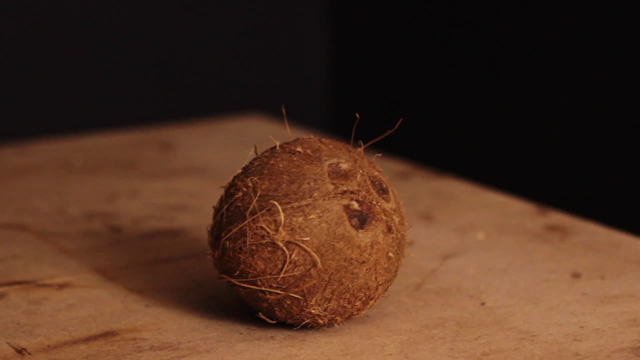 Rotating around a whole coconut on a wooden chopping board