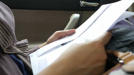 woman reading documents in a car