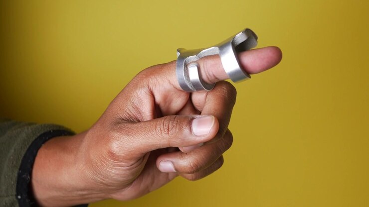 Persona che indossa un tutore metallico per dito per il recupero da un infortunio