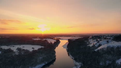 Aerial,-edited---Fast-flight-backwards-above-misty-river-running-through-snowy-pine-forest-with-mountain-in-the-background