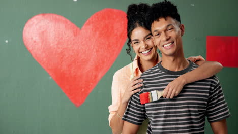 young couple painting a heart on the wall