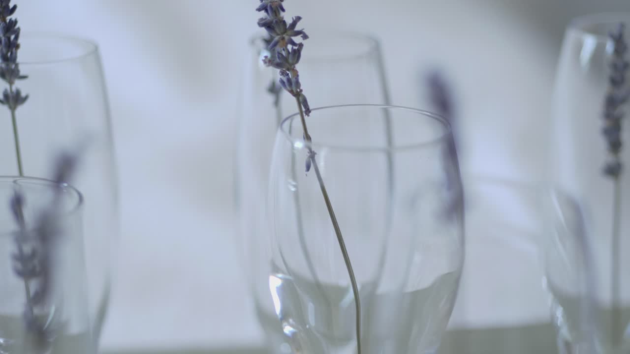 fotocamera lenta pan bicchiere di champagne vuoto con fiori di lavanda