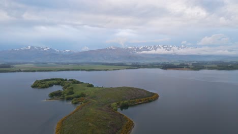 Aerial-view-of-a-tiny-island-on-a-mountain-lake-during-blue-hour-in-New-Zealand