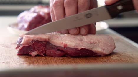 chef preparing piece of lamb meat for cooking