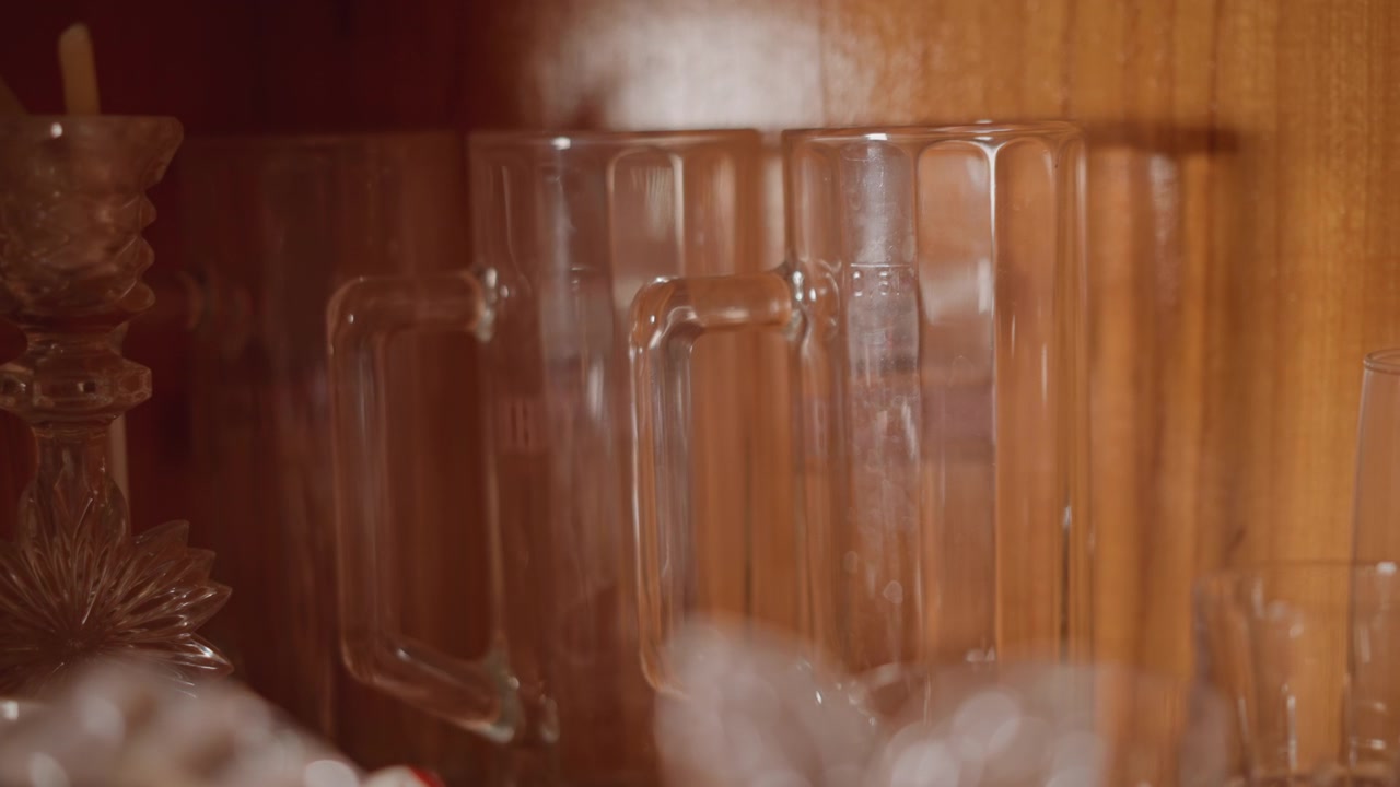 Vintage crystal mugs on wooden shelf, warm ambient glow and neat arrangement with candle holder accent, clear reflections and soft bokeh create elegant still display ideal for decor or antique