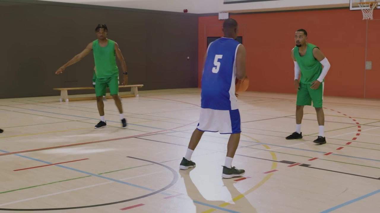 Video verticale: Iniziando il palleggio, maglia blu numero 5 che sonda un varco e si lancia in palestra, con sovrapposizione della palla
