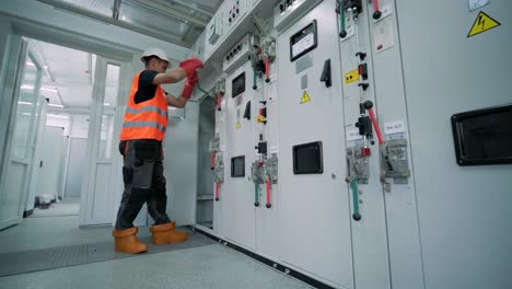 los ingenieros eléctricos inspeccionan los sistemas eléctricos en el gabinete de control de equipos