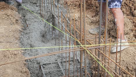 el hormigón se vierte en la zanja de refuerzo de la barra de refuerzo para la fundación de la casa