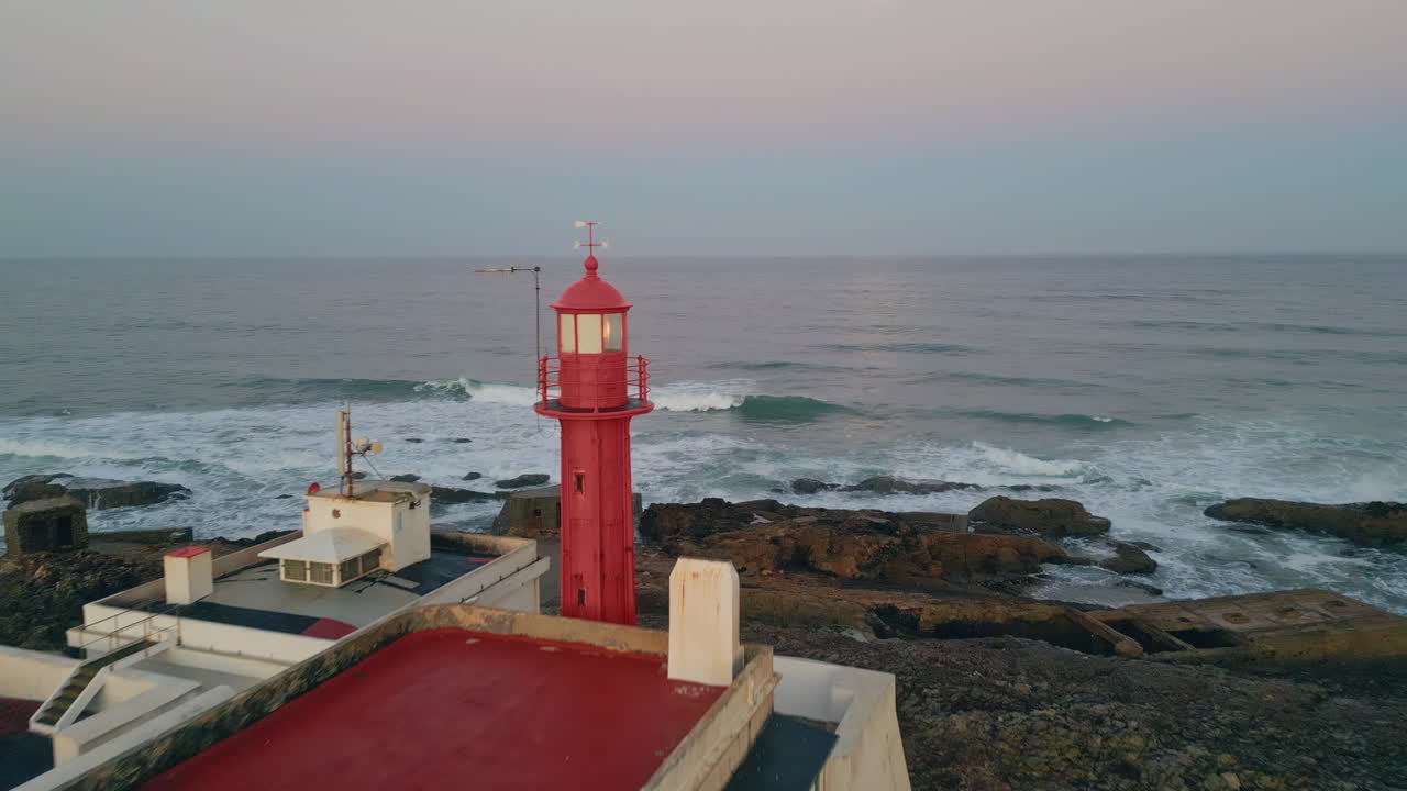 Red beacon placed ocean shore washed by stormy waves drone view. Sea lighthouse