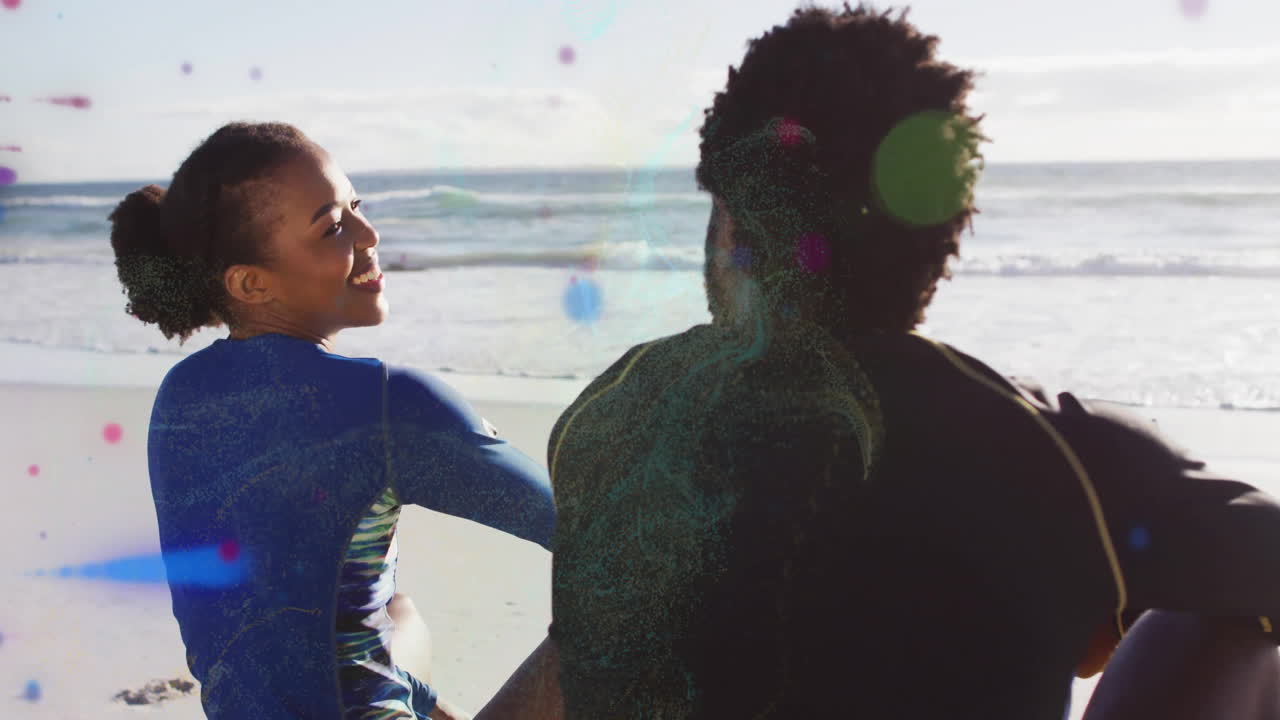 Sitting on beach, two people relaxing under sun with ocean view