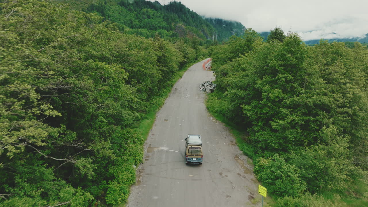 Camping van drives down rural gravel road