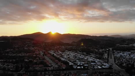 Drone-shot-panning-while-overlooking-a-city-during-sunset