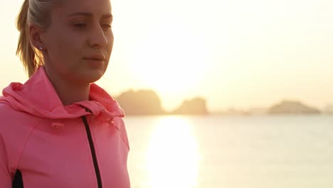 handheld video shows of sporty woman running on the beach